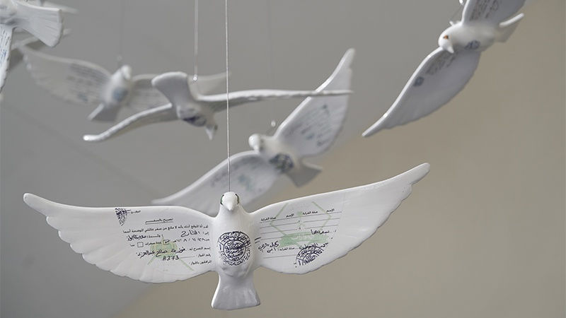 Porcelain doves inscribed with Arabic documents, suspended in air